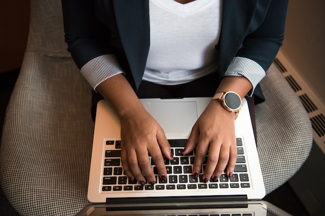 image of a woman's hands typing on a laptop