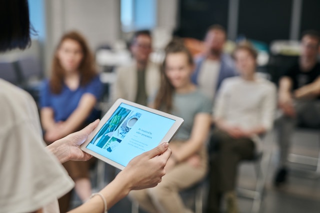 photo of person presenting to a room of people