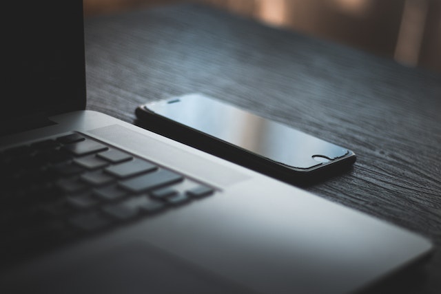 photo of a laptop and mobile phone sitting on table