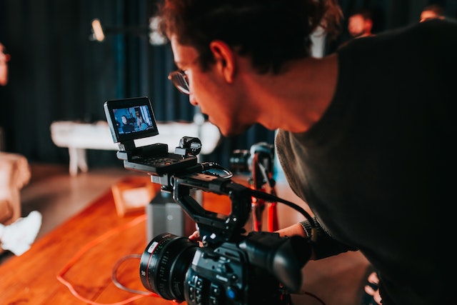 photo of a young person using a video camera to record a video