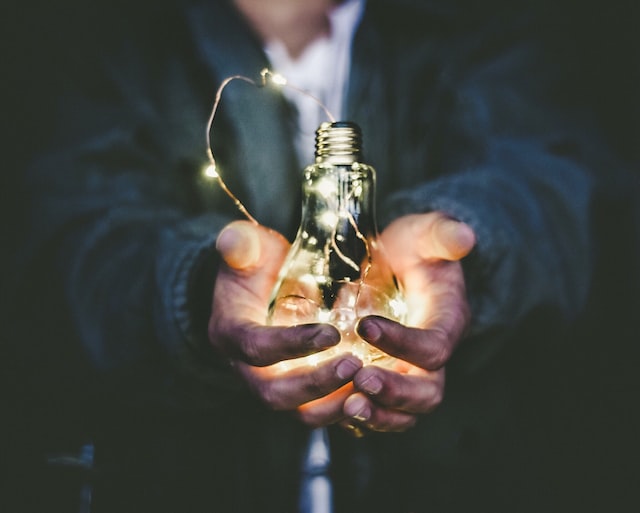 person holding a light in their hands with their hands outstretched