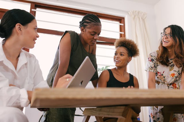 photo of women working and talking around a table