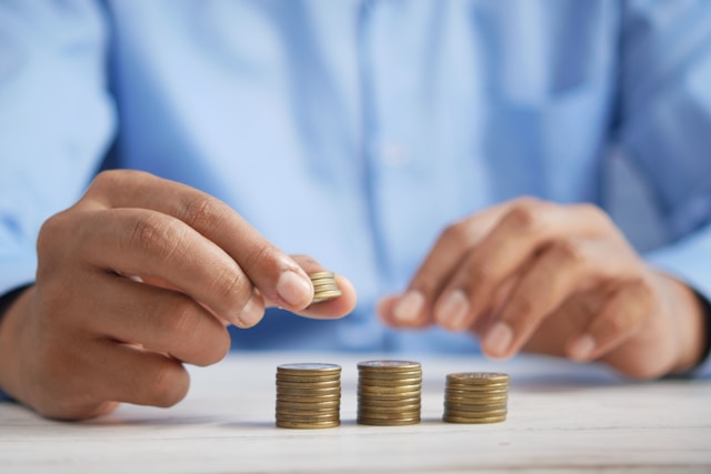 close up of a person's hands stacking coins